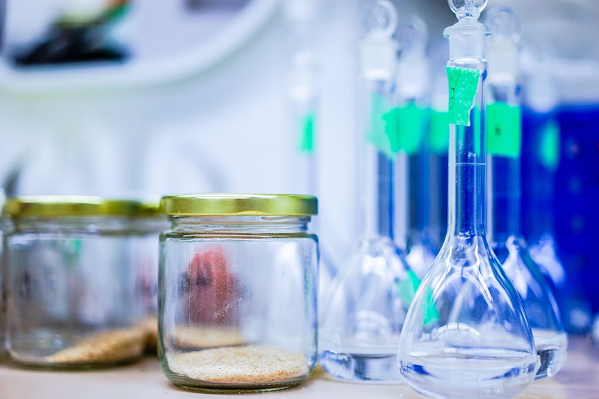 Laboratory glassware with blue liquid and chemical samples