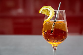 Aperol Spritz cocktail with orange slice and metal straw