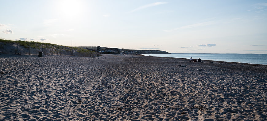 Wide Panoramic View of Sandy Beach at Sunset with Dunes