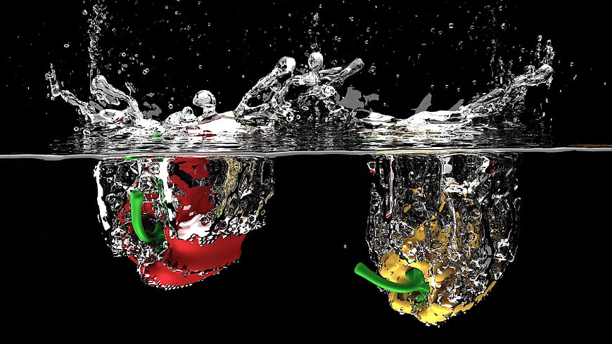 Red and yellow bell peppers splashing into water