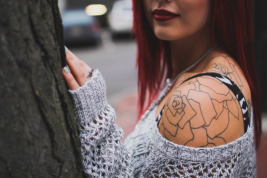 Woman with Red Hair and Rose Tattoo Leaning on Tree