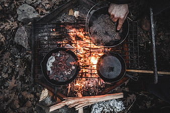 Top view of cast iron skillets cooking over campfire