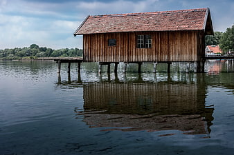 Rustic wooden house on stilts over calm river water
