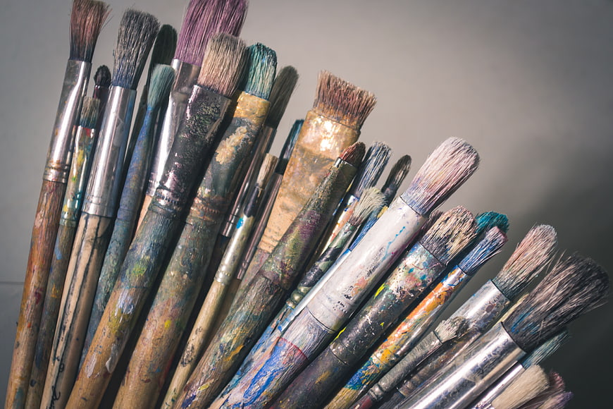 Collection of used paintbrushes with dried paint