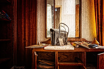 Vintage leather bag on wooden table in abandoned room