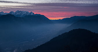 Dramatic mountain sunset with pink sky and misty valley