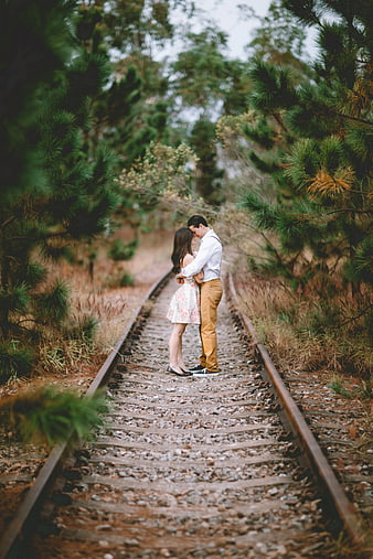Romantic Couple Embracing on Railroad Tracks in Forest