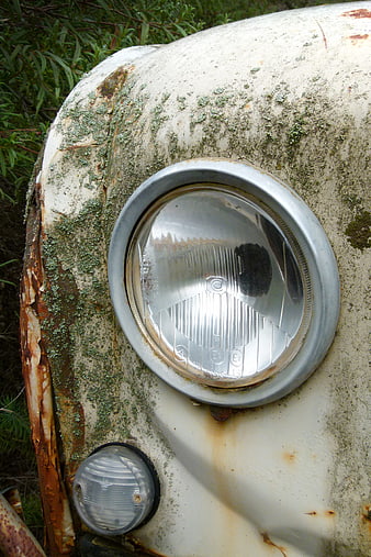 Close-up of Rusty Vintage Car Headlight with Moss