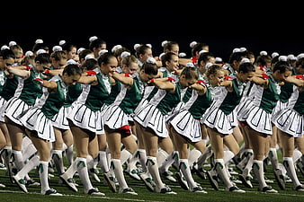 Cheerleaders in Green and White Uniforms Performing on Field