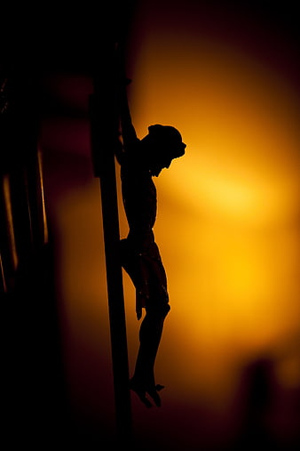 Silhouette of Jesus on Cross Against Golden Background