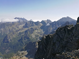 Panoramic View of Rugged Mountain Peaks Above Clouds