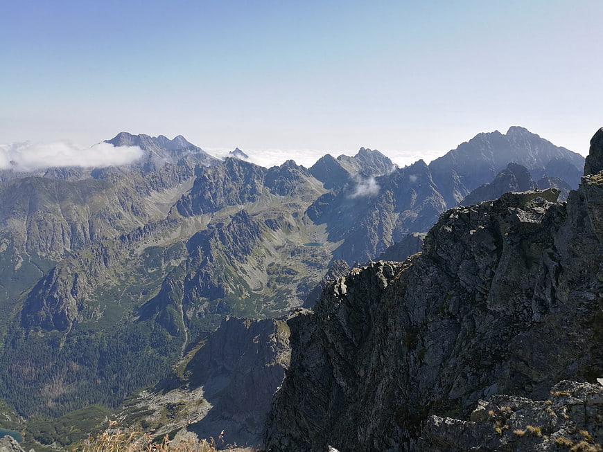 Panoramic View of Rugged Mountain Peaks Above Clouds