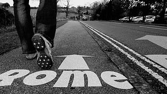 Person Walking on Road with Home Arrow Marking