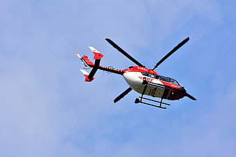 Red and White Rescue Helicopter Flying in Blue Sky