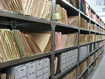 Rows of vintage paper files in metal archive shelves