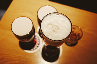 Top view of three creamy coffee drinks on wooden table