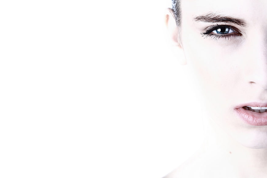 High-key studio portrait of a woman's face with blue eyes