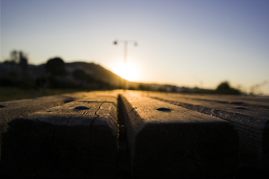 Close-up of wooden planks with blurred sunset background