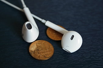 White Earphones and Russian Coins on Dark Wood