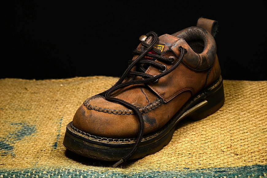 Vintage Brown Leather Work Boot on Textured Burlap