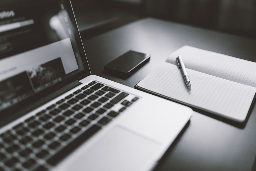 Minimalist workspace with laptop, notebook, and smartphone