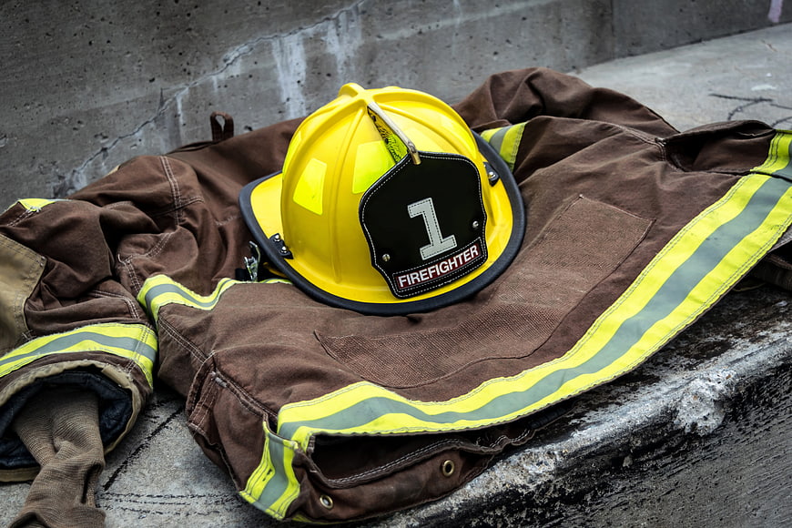 Yellow Firefighter Helmet and Brown Protective Gear on Concrete