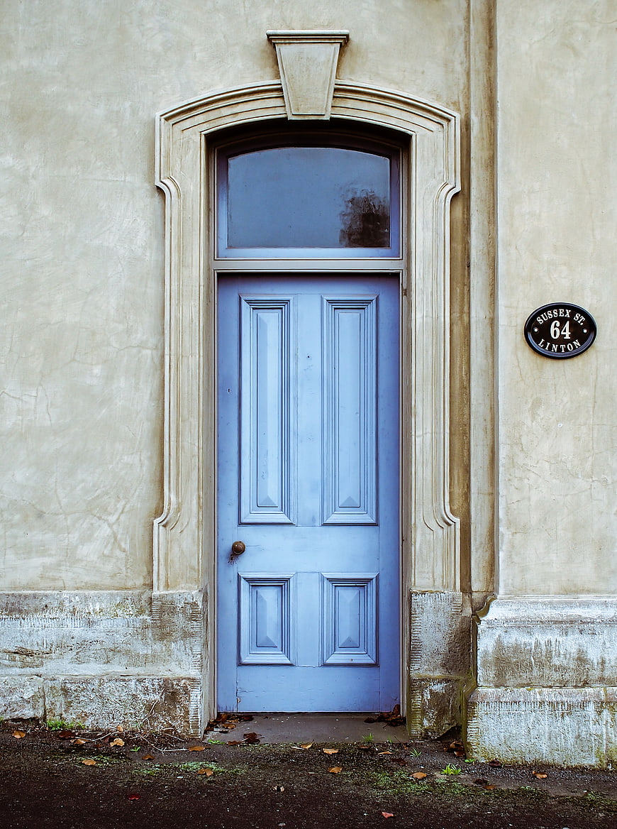 Blue Door on Beige Wall with Street Sign