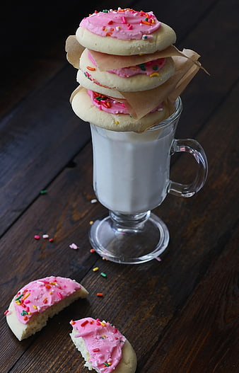 Stacked Sugar Cookies with Pink Frosting and Sprinkles on Milk Glass
