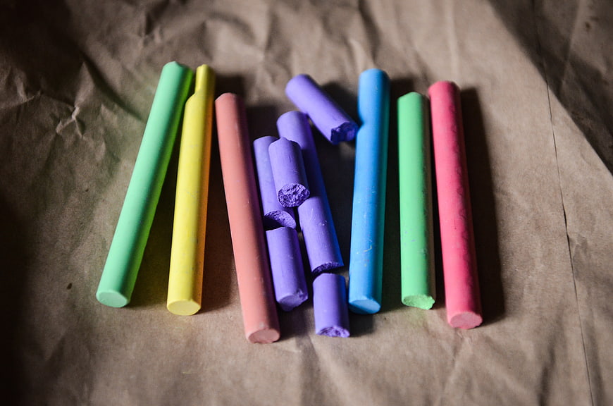 Colorful chalk sticks on crumpled brown paper background