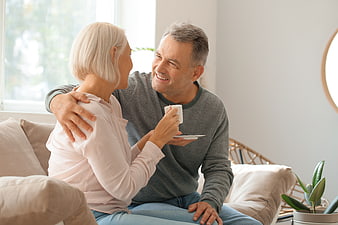 Happy Senior Couple Laughing Together on Sofa at Home