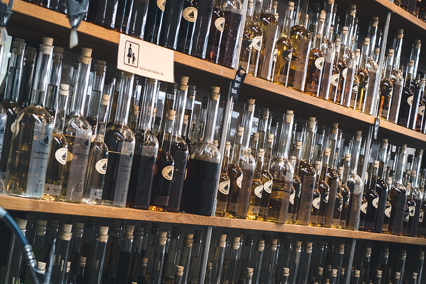 Shelves of homemade liqueur bottles in a store