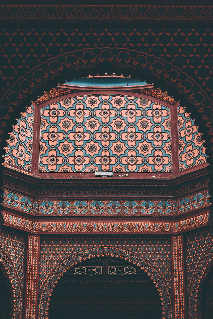 Intricate Islamic geometric ceiling patterns in teal and terracotta