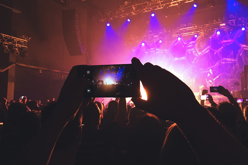 Silhouette of hands recording concert on smartphone