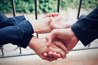 Close-up of multiple hands stacked together outdoors