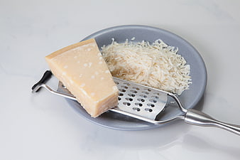 Parmesan Cheese Wedge With Grater And Shreds On Plate