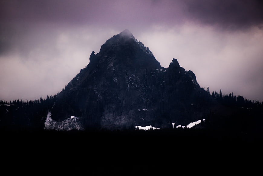 Dark moody mountain peak shrouded in mist and clouds