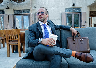 Stylish Businessman with Briefcase and Coffee on Outdoor Sofa