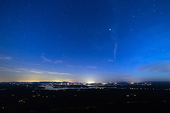 Night Sky Panorama Over Lake and Distant City Lights