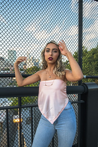 Stylish Blonde Woman in Pink Top on Urban Bridge