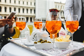 Aperol Spritz cocktails on a silver tray with snacks