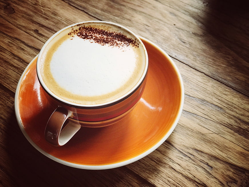 Cappuccino with Cocoa Powder on Wooden Table