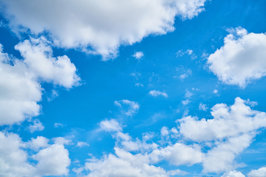 Bright Blue Sky with Fluffy White Clouds Background
