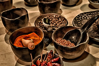 Rustic wooden bowls filled with colorful spices and dried chilies