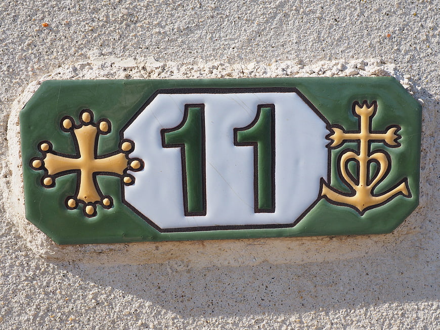 Green ceramic house number 11 tile with gold cross and anchor symbols