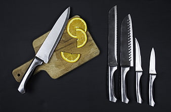 Kitchen knife set with orange slices on wooden board