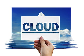 Hand holding cloud computing concept card against blue sky background