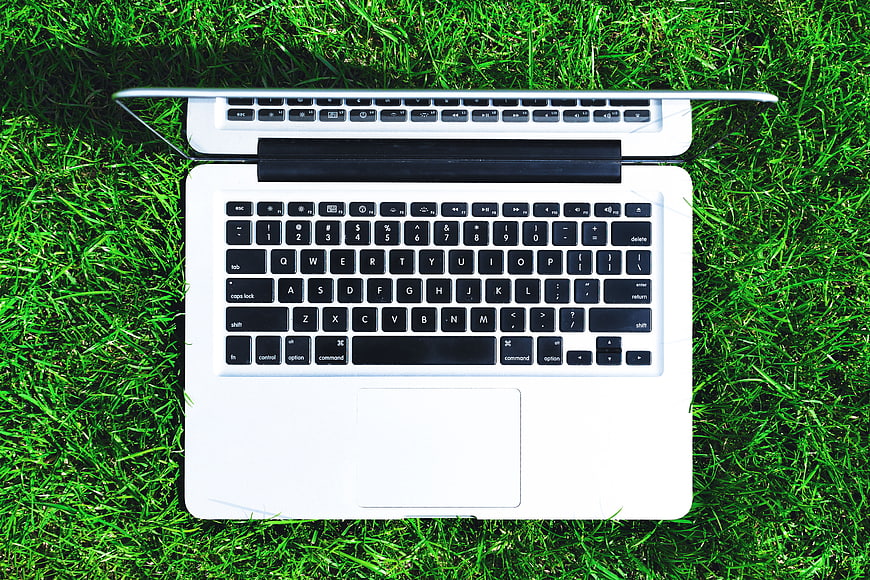 White Laptop on Green Grass Overhead View
