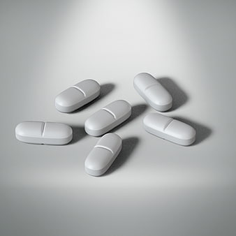White Capsule Pills Scattered On Gray Background