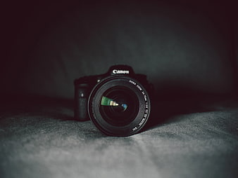 Black Canon DSLR Camera on Dark Textured Surface