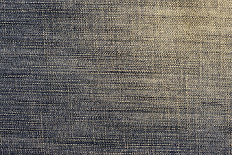 Close-up of vintage blue denim fabric texture with visible weave pattern